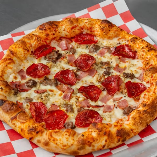 Flame and Cones Pizza with pepperoni, sausage, and ham on a red and white checkered paper.