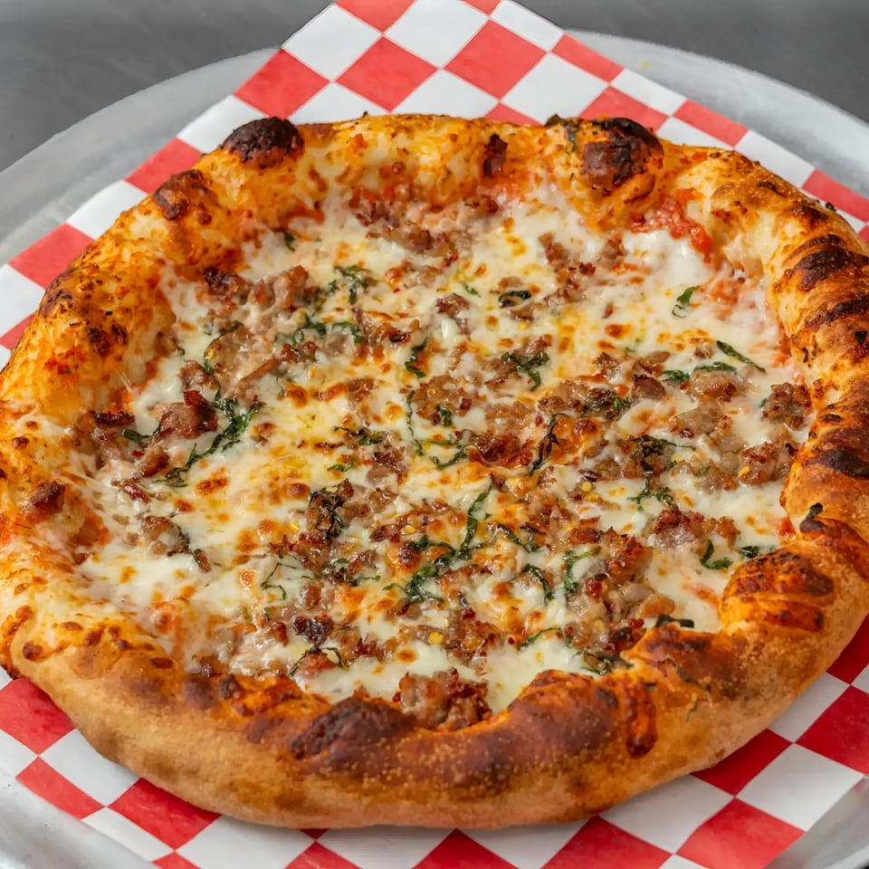 Flame and Cones Pizza's Italian sausage and basil pizza, with melted cheese and a golden crust.